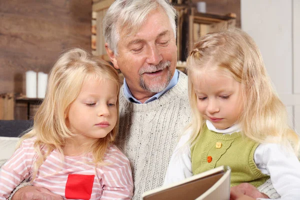 Oudere man met kleinkinderen thuis — Stockfoto
