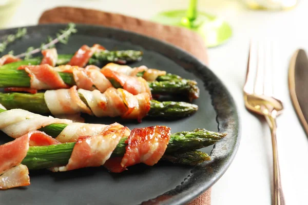 Plate with bacon wrapped asparagus on table, closeup — Stock Photo, Image