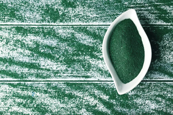 Piatto e spirulina in polvere sul tavolo — Foto Stock