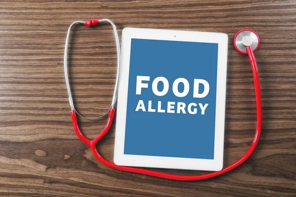 Стетоскоп і планшет з текстом FOOD ALLERGY на дерев'яному фоні — стокове фото