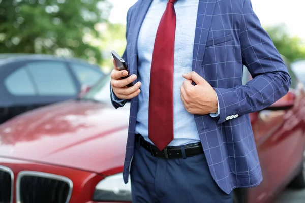 Красивый успешный бизнесмен возле автомобиля на открытом воздухе — стоковое фото