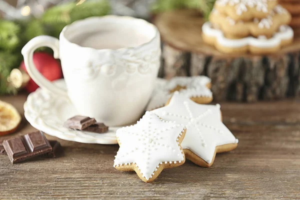 Creatieve kerstkoekjes en kopje warme dranken op tafel — Stockfoto