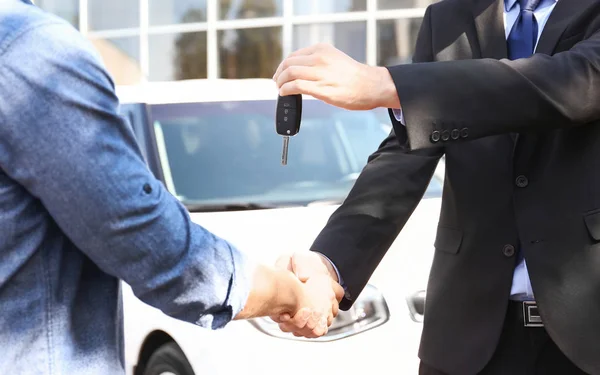 Salesman memberikan kunci mobil untuk pelanggan di luar ruangan — Stok Foto