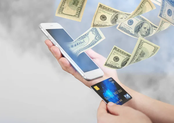 Money flying out of smartphone while woman using it on blurred background