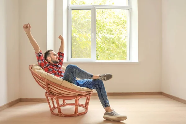 Young man resting in armchair near window at home — Stock Photo, Image