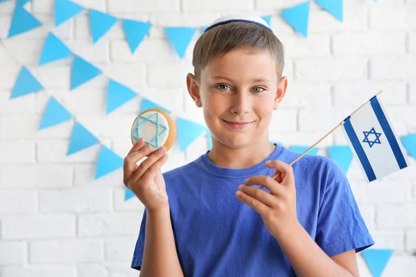 Joodse jongen met feestelijke Hanukkah cookie en vlag thuis — Stockfoto