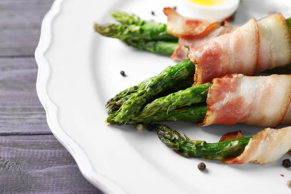 Placa con tocino envuelto espárragos en la mesa, primer plano —  Fotos de Stock