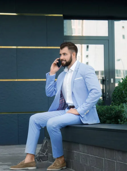Schöner erfolgreicher Geschäftsmann, der im Freien mit dem Handy telefoniert — Stockfoto