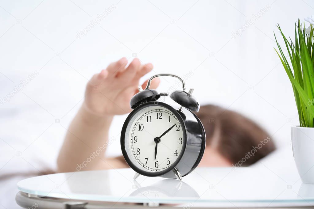 Woman turning off alarm clock 