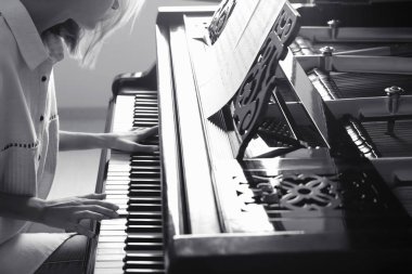 Talented woman playing piano indoors, black and white effect clipart