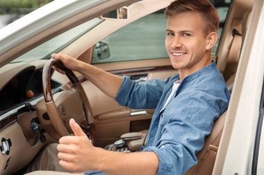 Araba sürücü koltuğunda genç adam