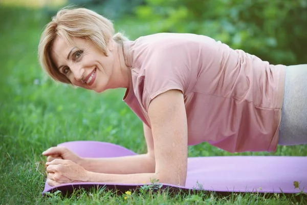 Zralá žena cvičí jógu — Stock fotografie