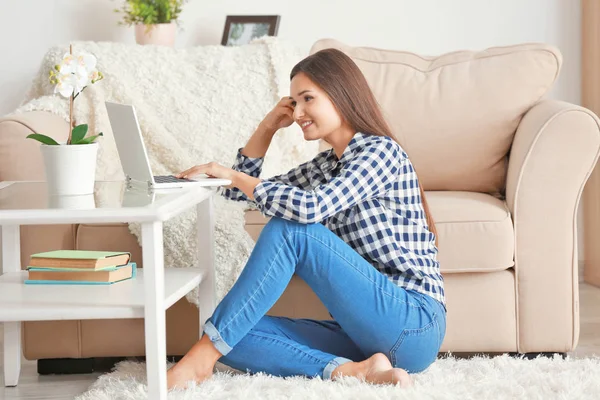 Szép nő, modern laptop otthon a szőnyegen ülve — Stock Fotó