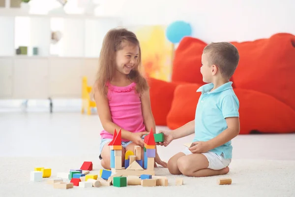 Милые дети играют с блоками в помещении — стоковое фото