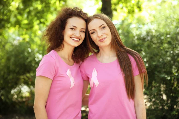 Mujeres jóvenes con camisetas rosas al aire libre. Concepto de conciencia sobre el cáncer de mama — Foto de Stock