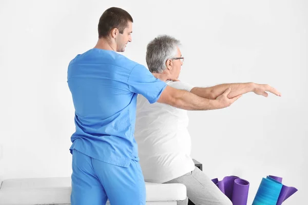Fyzioterapeut pracující s starší pacient v moderní klinika — Stock fotografie