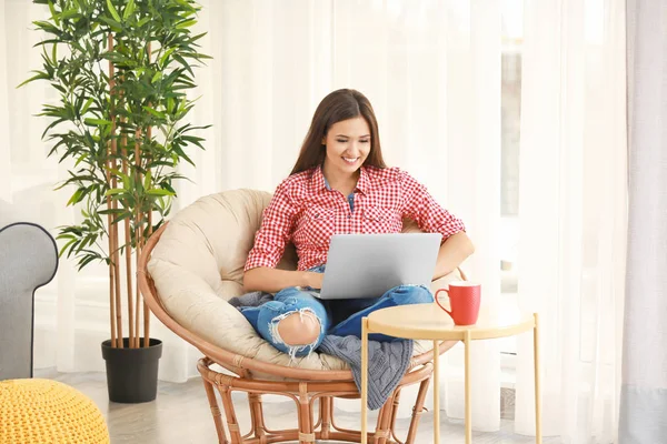 Hübsche Frau mit modernem Laptop ruht zu Hause im Loungesessel — Stockfoto