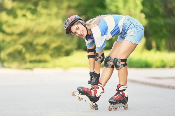 Молодая женщина на роликовых коньках в летнем парке — стоковое фото