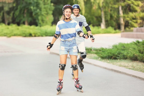 Pareja joven en patines en el parque de verano —  Fotos de Stock