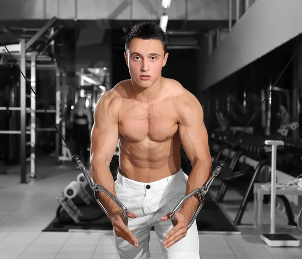 Jeune homme sportif s'entraînant en salle de gym — Photo