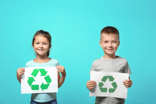色の背景上のシンボルのリサイクル用紙を保持している小さな子供たち — ストック写真
