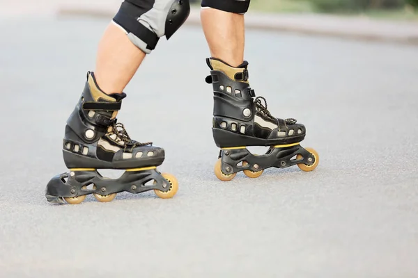 Legs of young man on roller skates — Stock Photo, Image