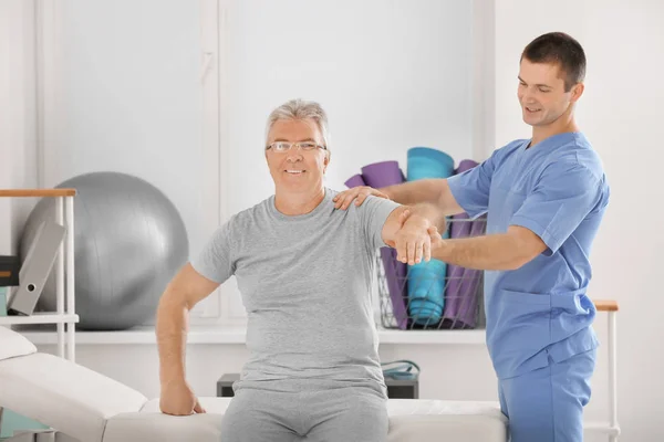 Fyzioterapeut pracující s starší pacient v moderní klinika — Stock fotografie