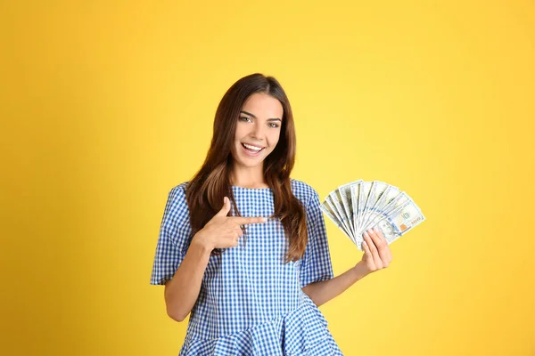 Bella giovane donna con soldi su sfondo di colore — Foto Stock