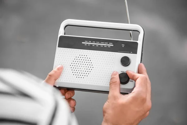 Young man holding retro radio outdoors