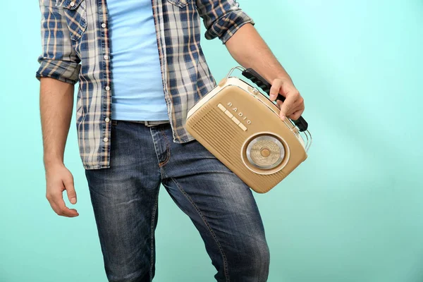 Young man holding retro radio on color background — Stock Photo, Image