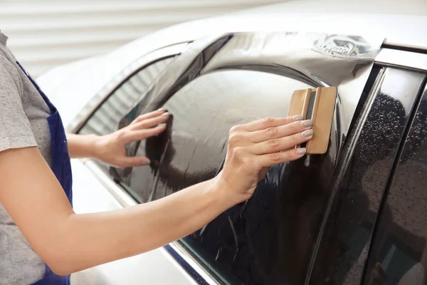 Female worker tinting car window — Stock Photo, Image