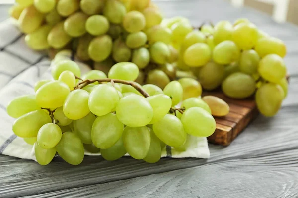 Uvas frescas maduras sobre tabla de madera — Foto de Stock