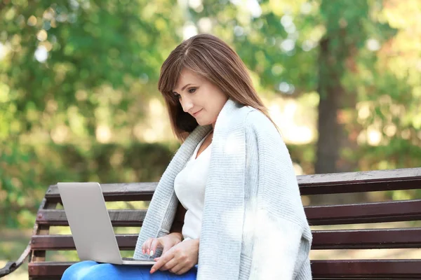 成熟的女人在户外使用笔记本电脑 — 图库照片