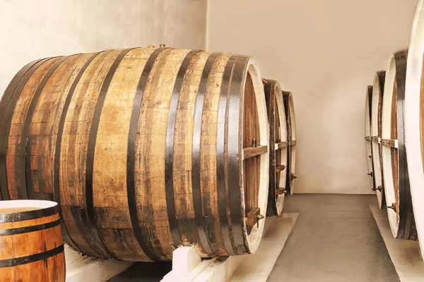 Barris de madeira com vinho na adega — Fotografia de Stock