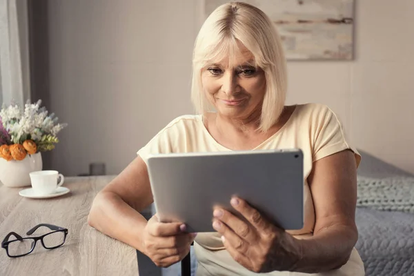 Mulher madura usando tablet em casa — Fotografia de Stock