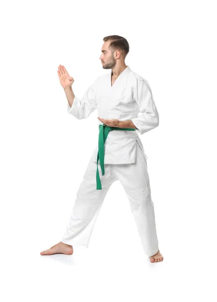 Mladý muž cvičí karate na bílém pozadí — Stock fotografie