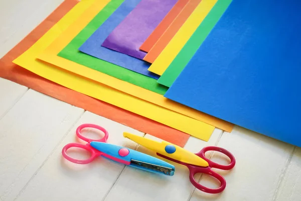 Color sheets with scissors for kindergarten on wooden background — Stock Photo, Image