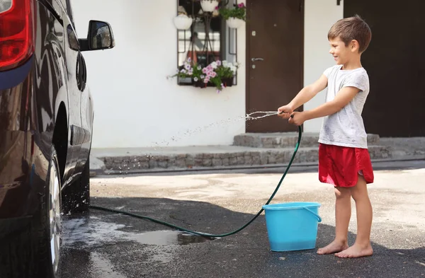 Mignon garçon lavage voiture à l'extérieur — Photo