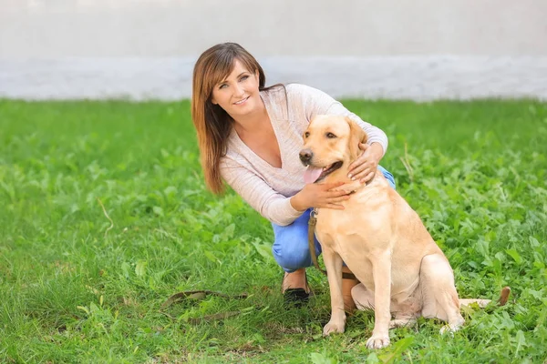 Wanita dewasa dengan anjingnya di taman — Stok Foto