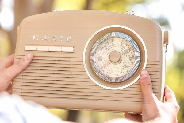 Joven sosteniendo radio retro al aire libre — Foto de Stock