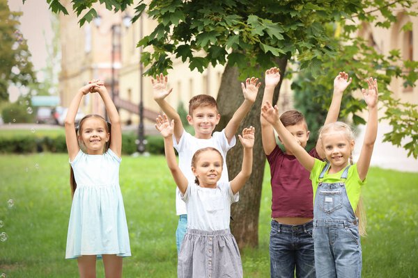 Cute little children playing in green park