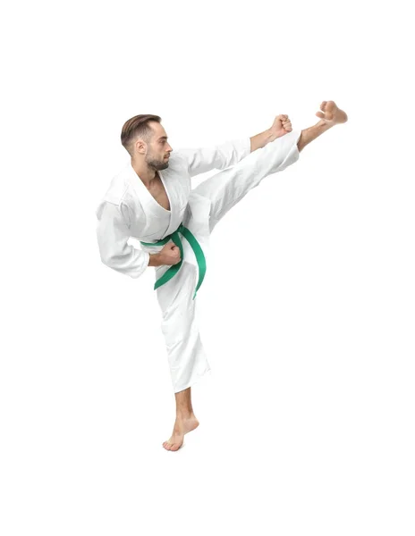 Mladý muž cvičí karate na bílém pozadí — Stock fotografie