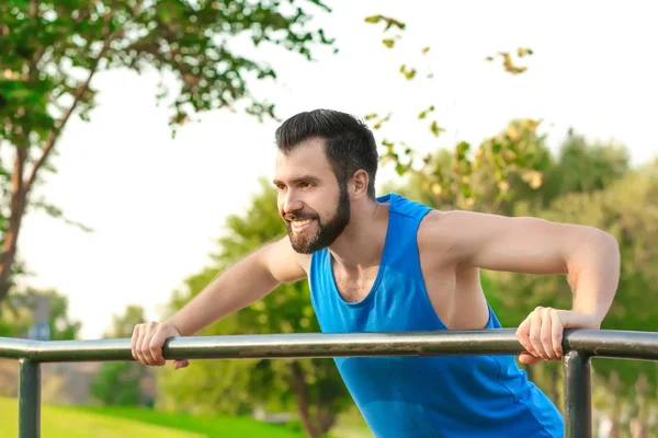 Handsome young man exercising in park — Stock Photo, Image