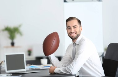 Yakışıklı delikanlı için Office Amerikan futbolu topu ile