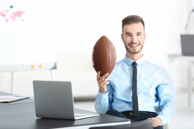 Yakışıklı delikanlı için Office Amerikan futbolu topu ile