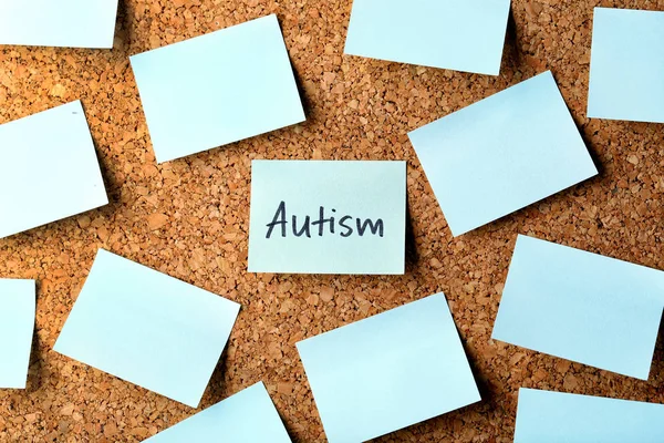 Nota con la parola AUTISM su sfondo sughero — Foto Stock