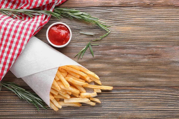 Papper kon med pommes frites på träbord — Stockfoto