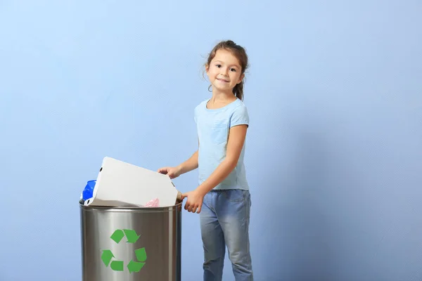 Küçük kız renk arka plan üzerinde çöp kutusu içine çöp atma. Geri dönüşüm kavramı — Stok fotoğraf