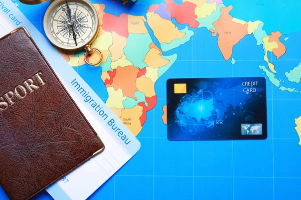 Composição com cartão de crédito e passaporte no fundo do mapa mundial — Fotografia de Stock