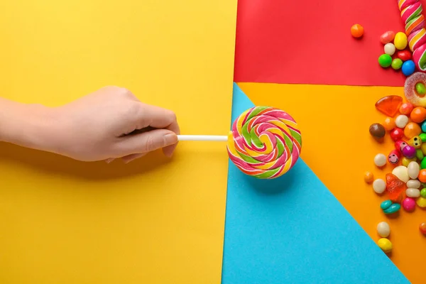 Kvinna med välsmakande lollipop på färgbakgrund — Stockfoto